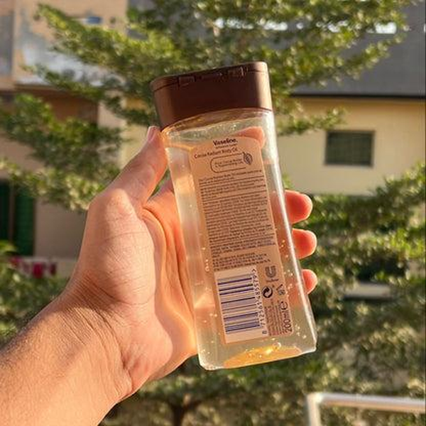 نمای پشت روغن ژلی بدن وازلین مدل Cocoa Radiant در فضای باز